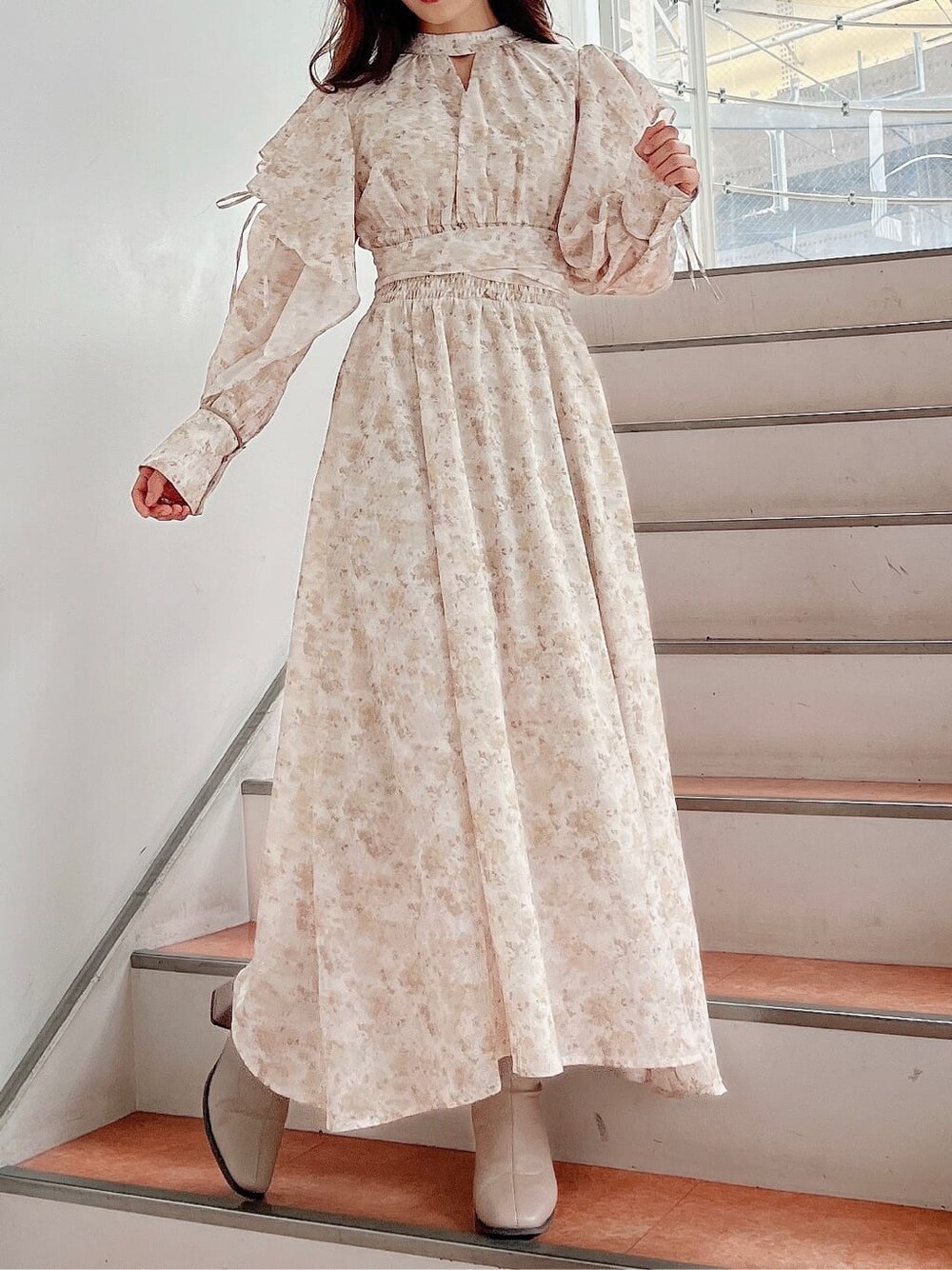 ベージュ系のワンピース、ベージュ系のブーツを着用したレディースの秋コーディネートの3枚目の写真