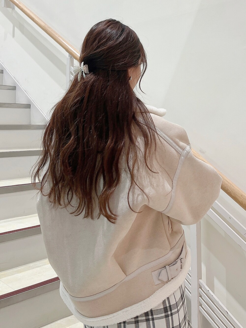 ホワイト系のブルゾン、ホワイト系のスカート、ベージュ系のブーツを着用したレディースの冬コーディネートの7枚目の写真