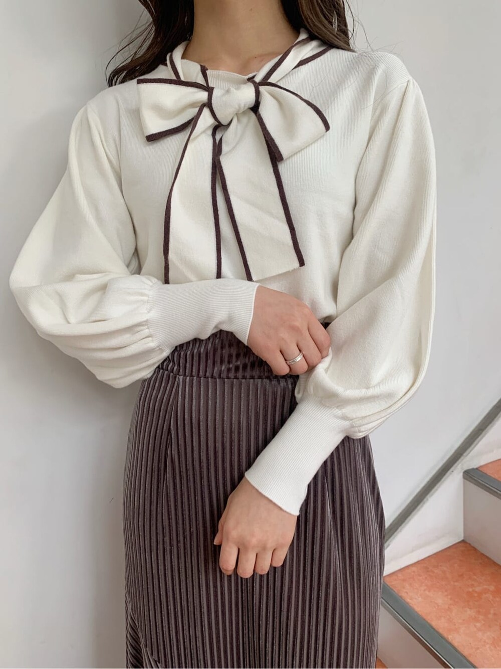 ホワイト系のニット/セーター、ブラウン系のブーツ、ベージュ系のスカートを着用したレディースの秋コーディネートの4枚目の写真