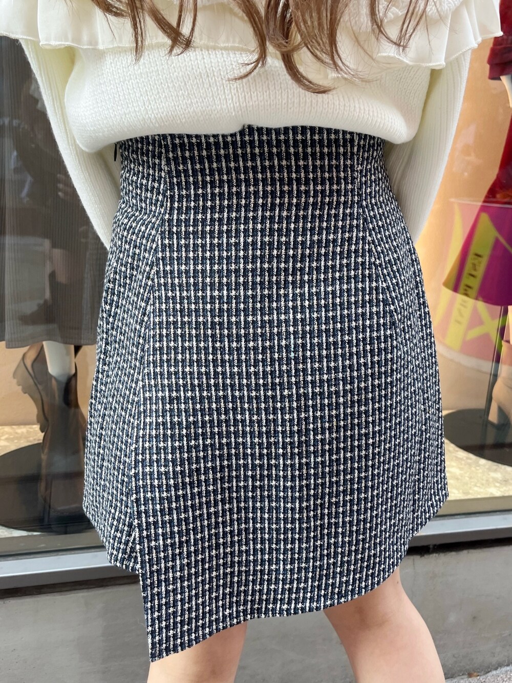 ホワイト系のニット/セーター、ブルー系のスカート、ブラック系のブーツを着用したレディースの秋コーディネートの9枚目の写真