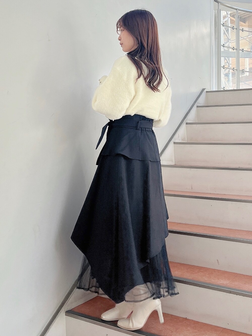 ホワイト系のブーツ、ブラック系のスカート、ホワイト系のニット/セーターを着用したレディースの秋コーディネートの3枚目の写真