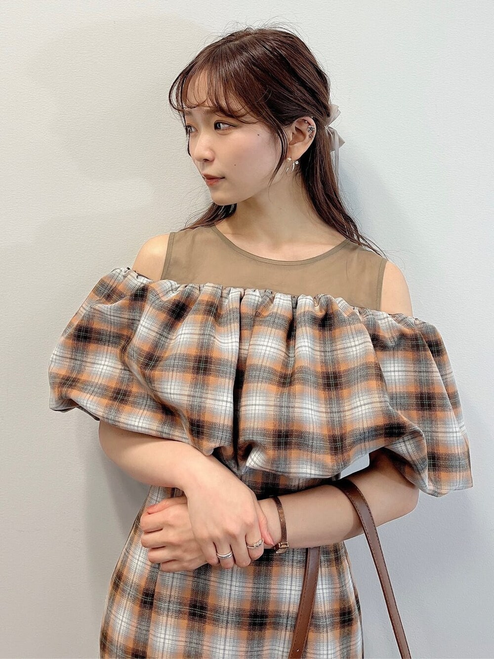 オレンジ系のワンピース、ベージュ系のブーツを着用したレディースの夏コーディネートの5枚目の写真