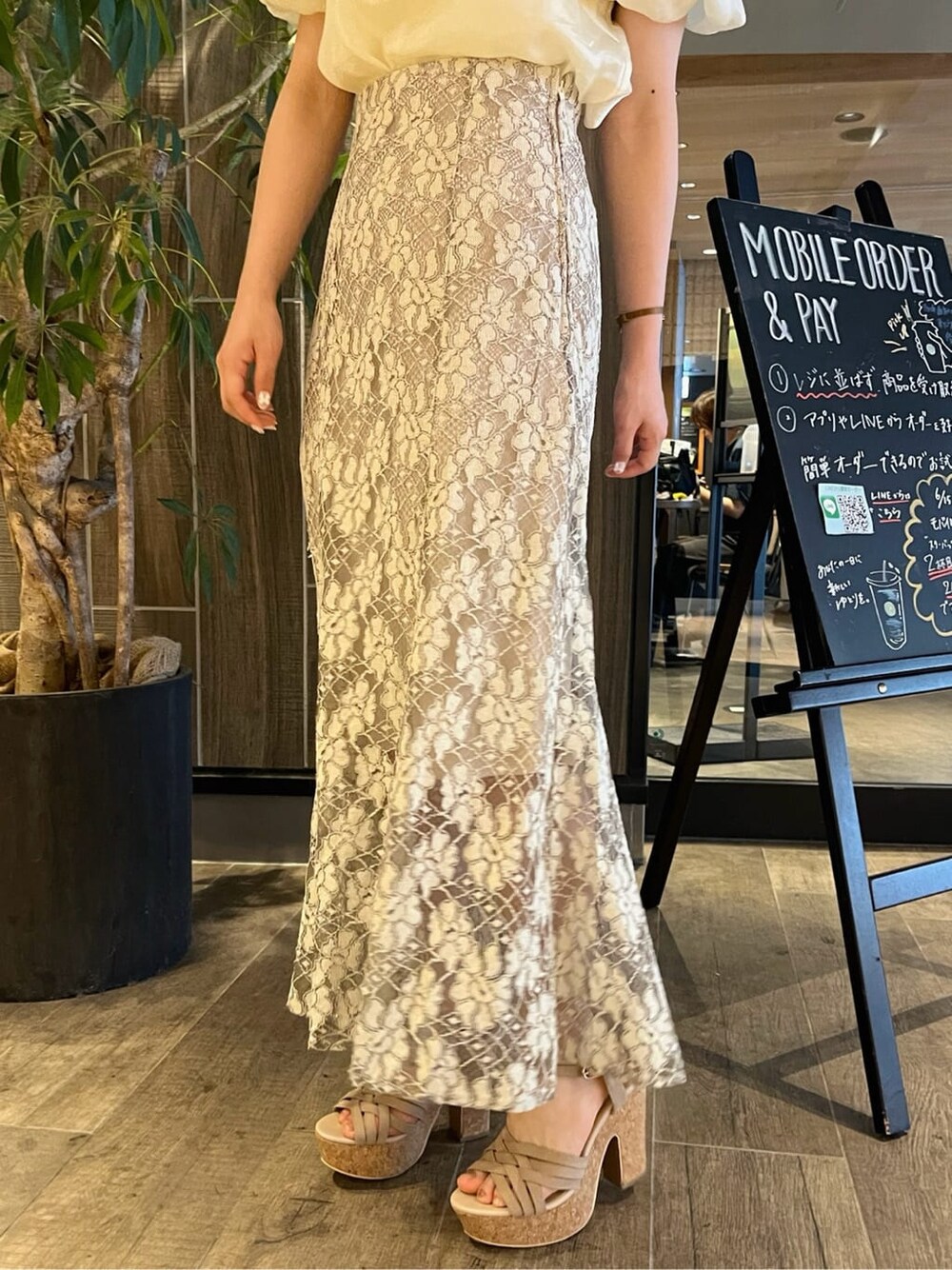 ベージュ系のスカート、ベージュ系のサンダル、イエロー系のシャツ/ブラウスを着用したレディースの夏コーディネートの9枚目の写真