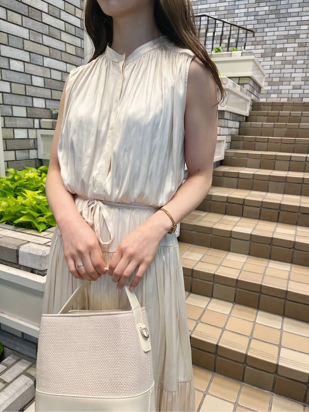 ベージュ系のトレンチコート、ホワイト系のワンピース、ホワイト系のパンプスを着用したレディースの冬コーディネートの4枚目の写真