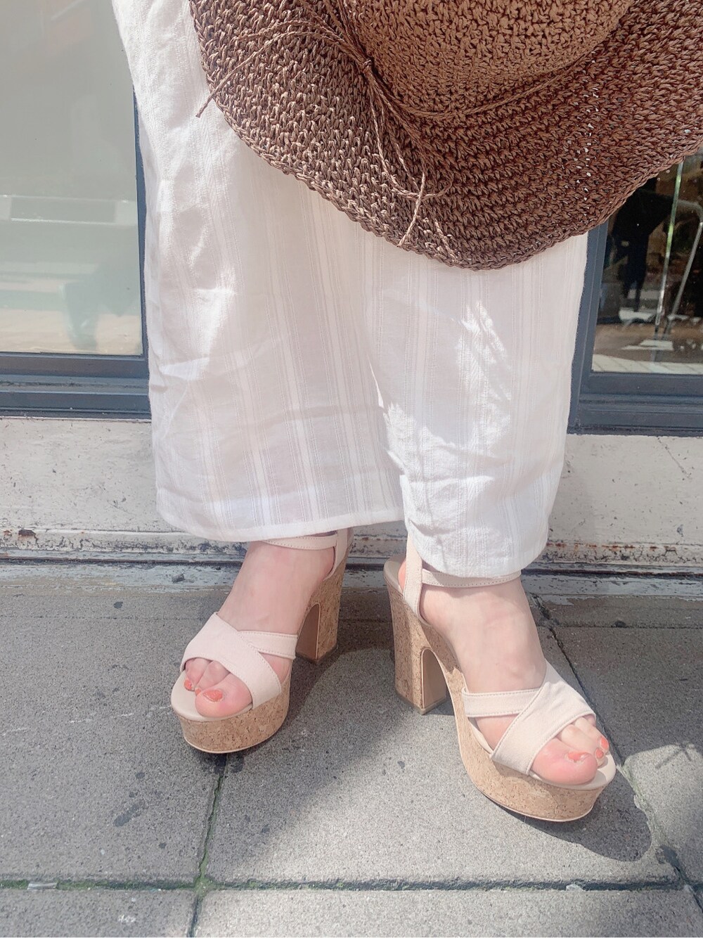 ホワイト系のワンピース、ベージュ系のサンダル、ブラウン系のハットを着用したレディースの春コーディネートの9枚目の写真