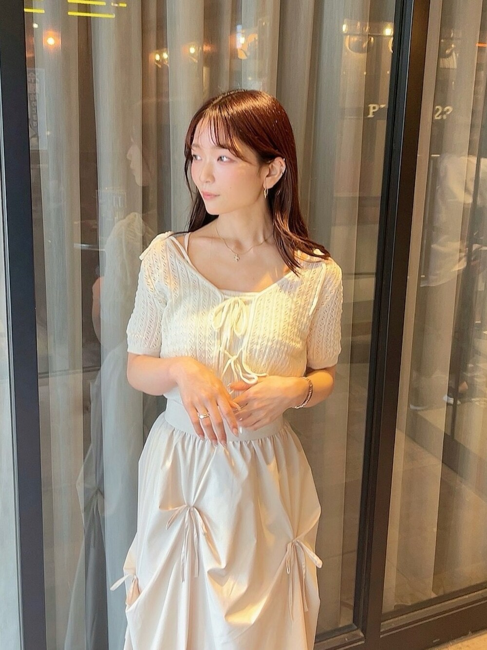 ホワイト系のニット/セーター、ホワイト系のスカートを着用したレディースの夏コーディネートの6枚目の写真