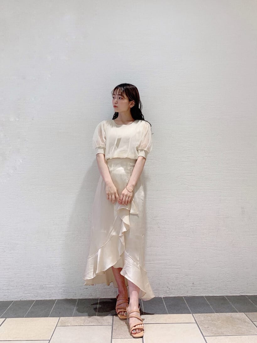 ホワイト系のスカート、ホワイト系のニット/セーター、オレンジ系のサンダルを着用したレディースの夏コーディネートの2枚目の写真