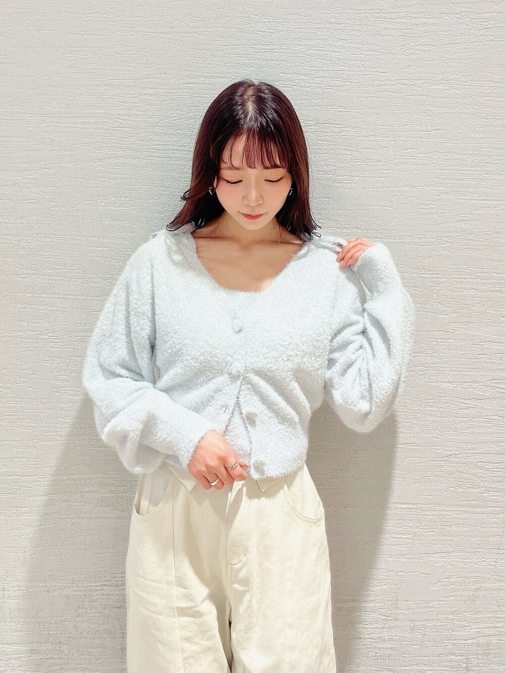 グレー系のキャミソール、グレー系のカーディガン/ボレロ、ホワイト系のデニムパンツを着用したレディースの冬コーディネートの7枚目の写真