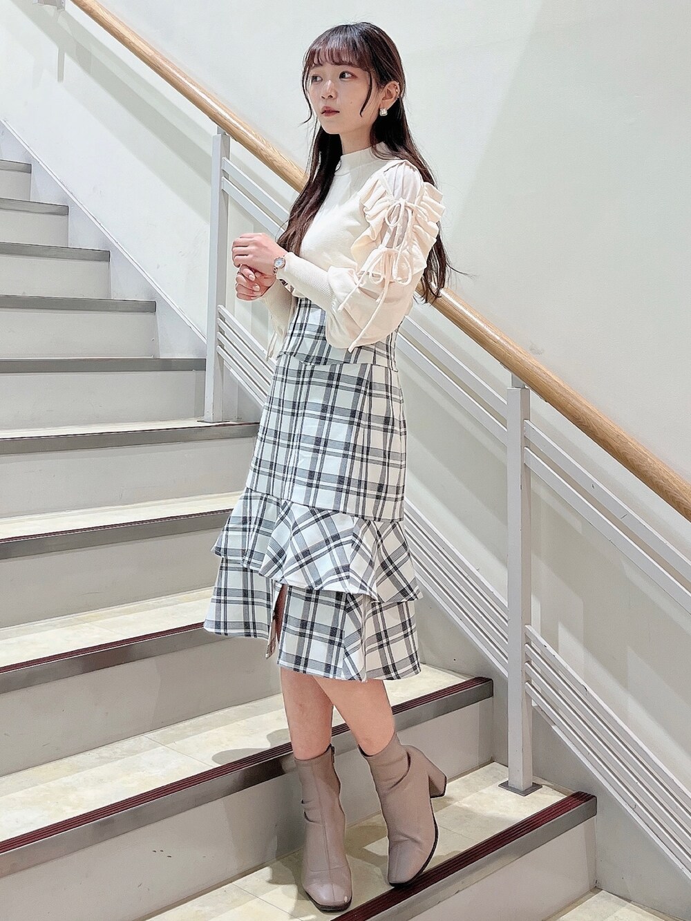 ホワイト系のニット/セーター、ホワイト系のスカート、ベージュ系のブーツを着用したレディースの冬コーディネートの3枚目の写真