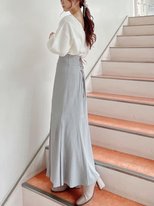 ベージュ系のブーツ、グレー系のスカート、ホワイト系のニット/セーターを着用したレディースの秋コーディネートの3枚目の写真