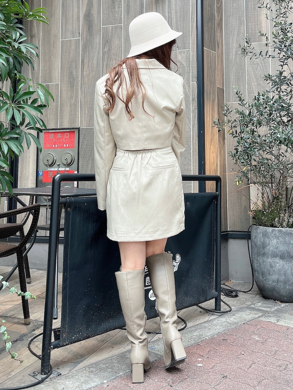 ベージュ系のテーラードジャケット、ホワイト系のニット/セーター、ベージュ系のスカートを着用したレディースの冬コーディネートの4枚目の写真