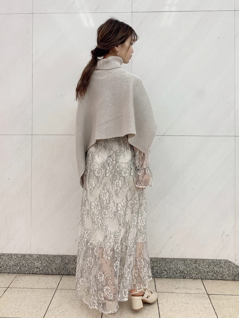 ホワイト系のワンピース、ベージュ系のニット/セーター、ホワイト系のパンプスを着用したレディースの秋コーディネートの7枚目の写真