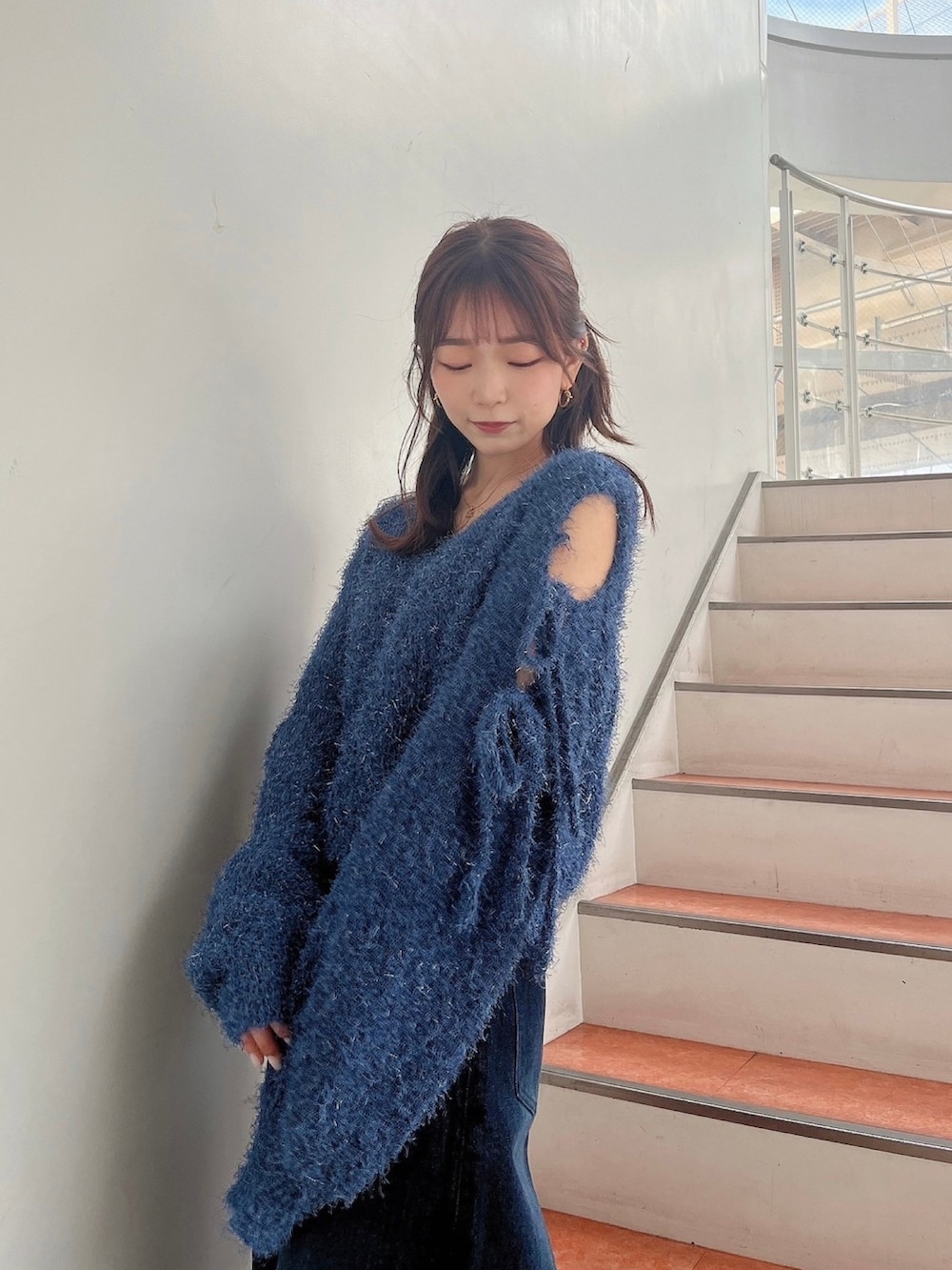 ブルー系のニット/セーター、ブルー系のデニムパンツ、ホワイト系のサンダルを着用したレディースの夏コーディネートの8枚目の写真