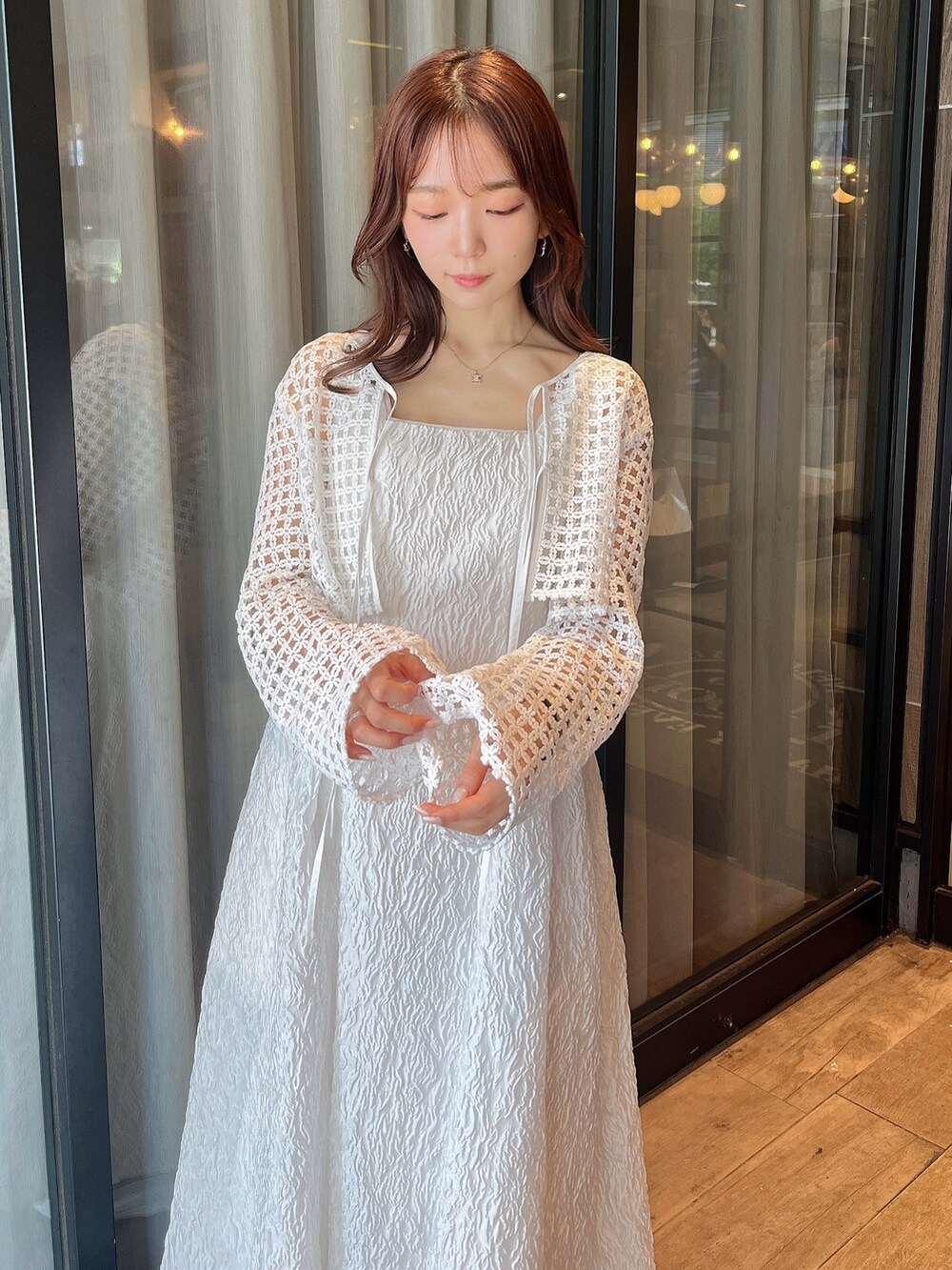 ホワイト系のドレス、ホワイト系のカーディガン/ボレロ、ホワイト系のサンダルを着用したレディースの夏コーディネートの4枚目の写真