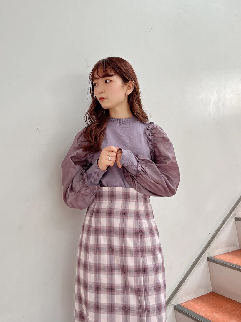 ブラック系のブーツ、パープル系のニット/セーター、パープル系のスカートを着用したレディースの冬コーディネートの6枚目の写真