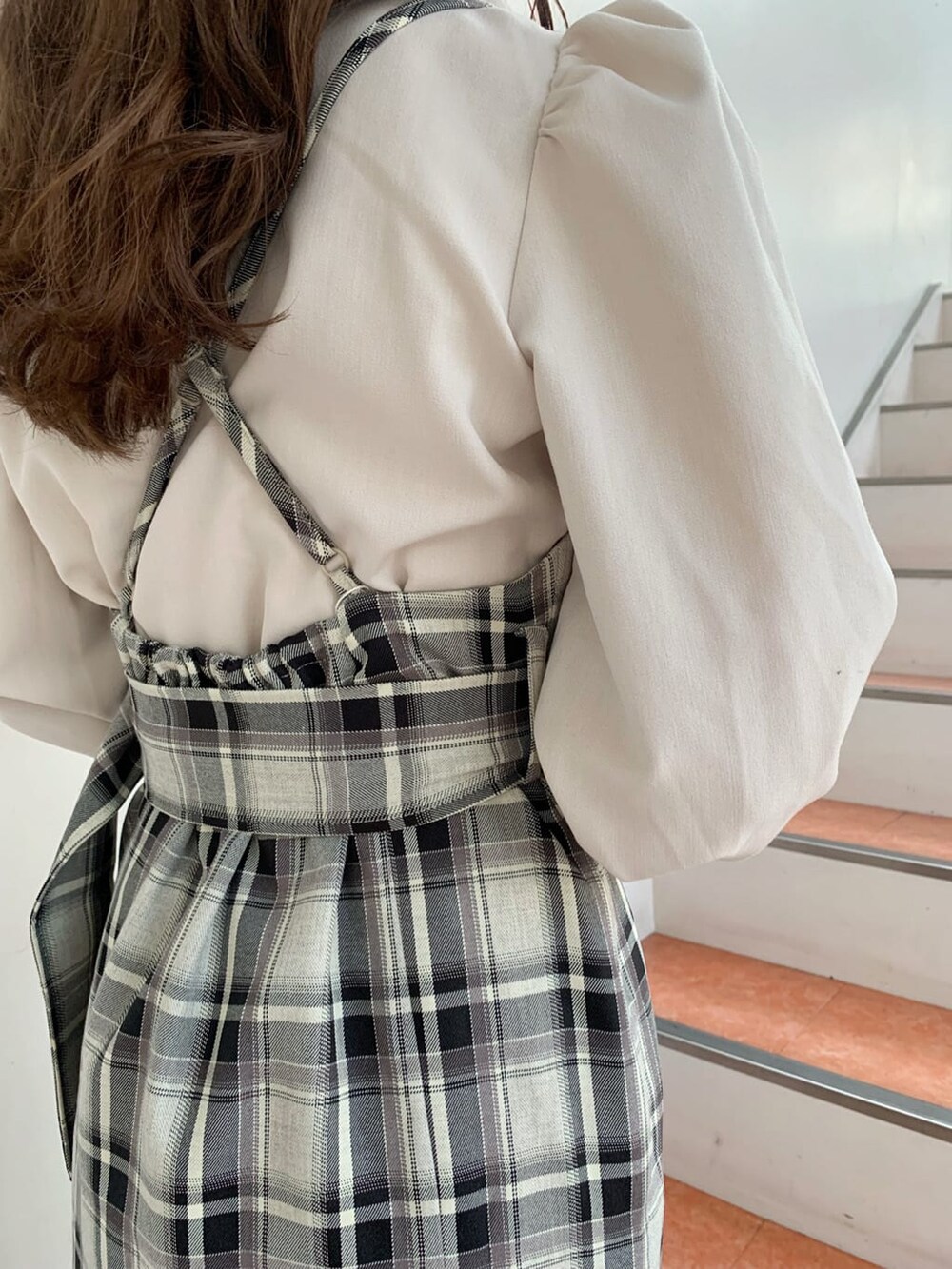 ブラウン系のブーツ、ベージュ系のシャツ/ブラウス、グレー系のジャンパースカートを着用したレディースの冬コーディネートの6枚目の写真