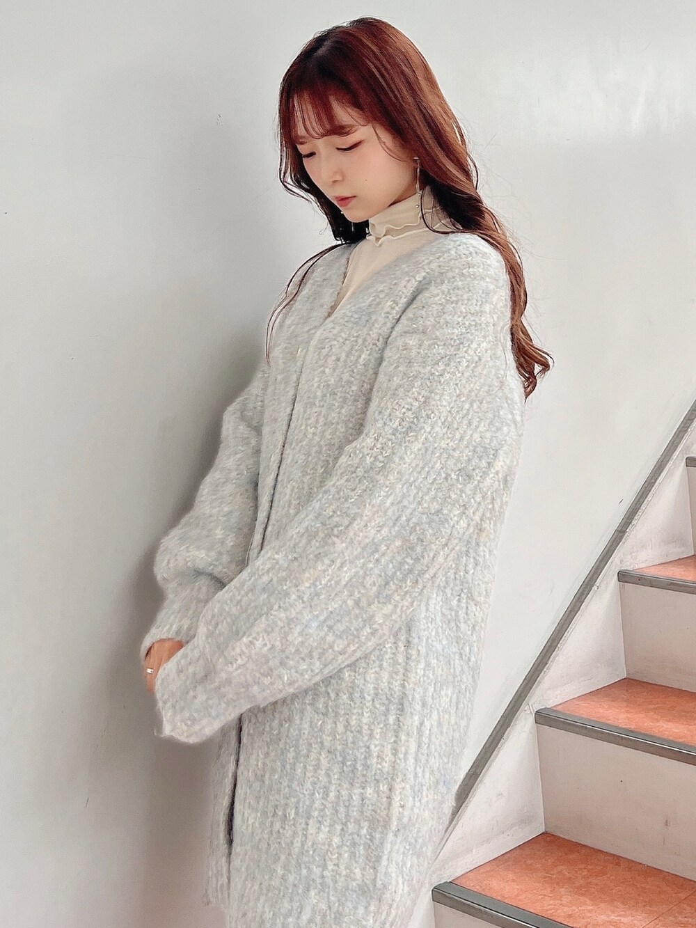 ホワイト系のTシャツ/カットソー、ブルー系のカーディガン/ボレロ、ベージュ系のブーツを着用したレディースの秋コーディネートの6枚目の写真