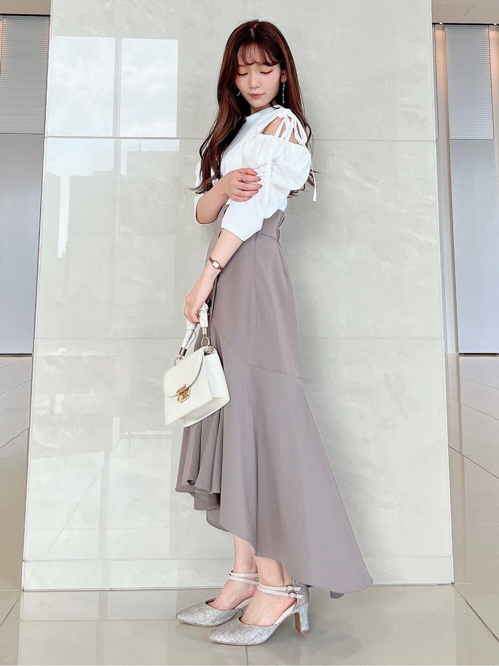 ベージュ系のスカート、ホワイト系のTシャツ/カットソーを着用したレディースの夏コーディネートの2枚目の写真