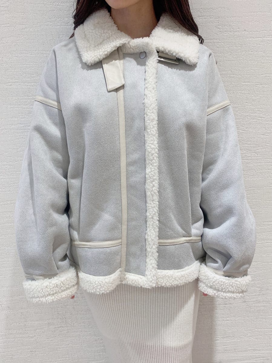 グレー系のブルゾン、ベージュ系のブーツ、ホワイト系のワンピースを着用したレディースの秋コーディネートの9枚目の写真