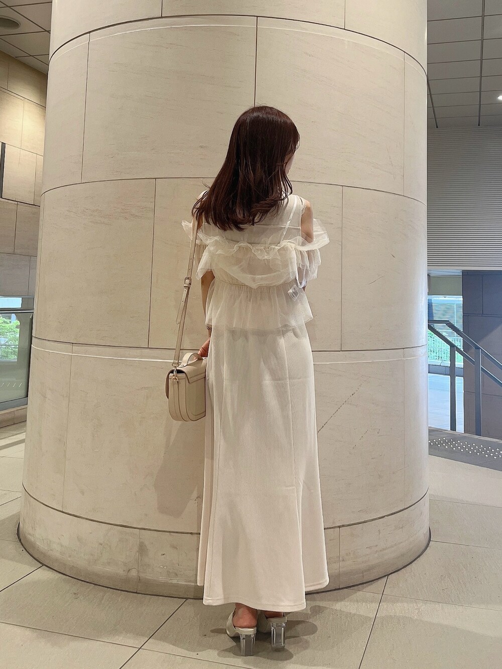 ホワイト系のワンピース、ホワイト系のパンプス、ホワイト系のハンドバッグを着用したレディースの夏コーディネートの4枚目の写真