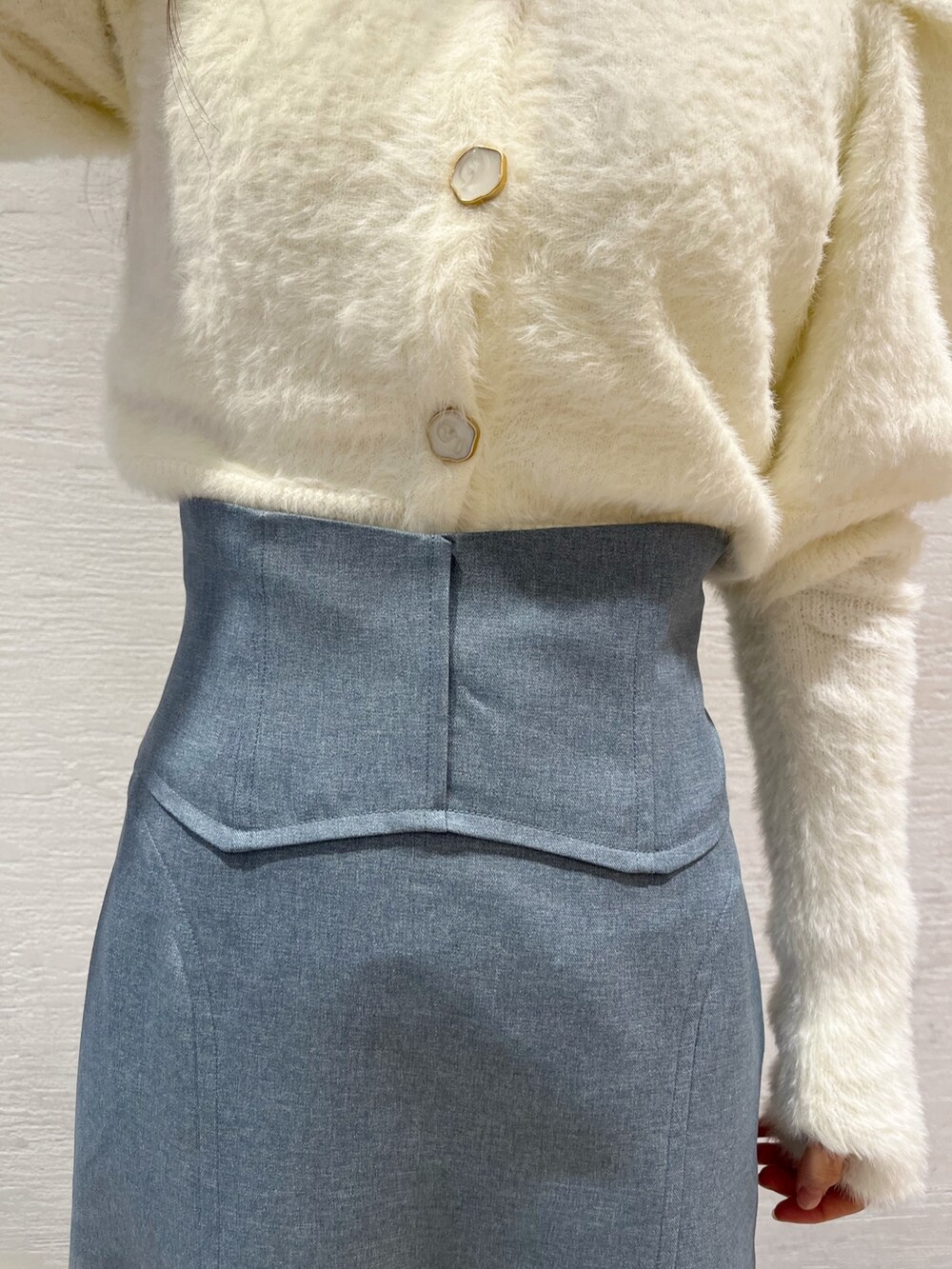 ホワイト系のニット/セーター、ブルー系のスカート、ベージュ系のブーツを着用したレディースの冬コーディネートの10枚目の写真