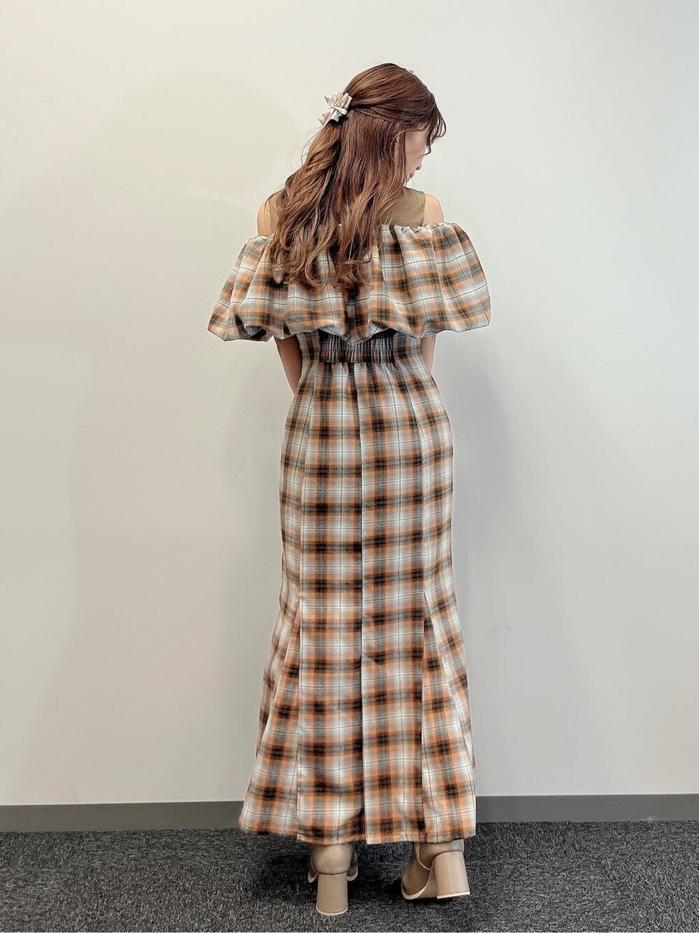 オレンジ系のワンピース、ベージュ系のブーツを着用したレディースの夏コーディネートの3枚目の写真