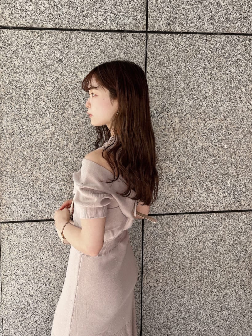 ピンク系のワンピース、ブラック系のブーツ、ホワイト系のショルダーバッグを着用したレディースの冬コーディネートの5枚目の写真