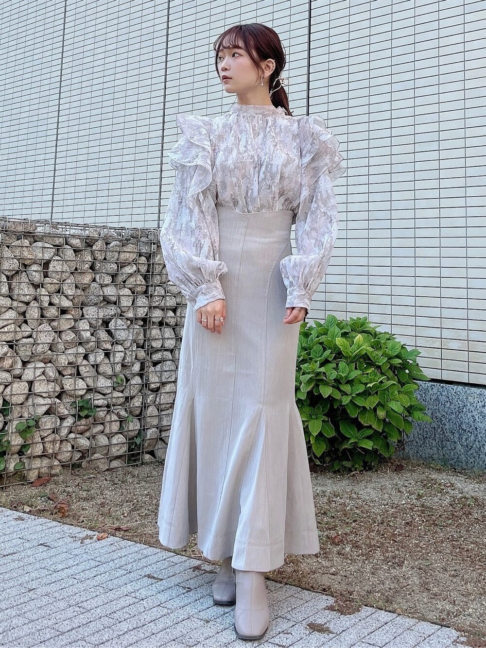 ベージュ系のスカート、ベージュ系のブーツ、ベージュ系のシャツ/ブラウスを着用したレディースの秋コーディネートの2枚目の写真