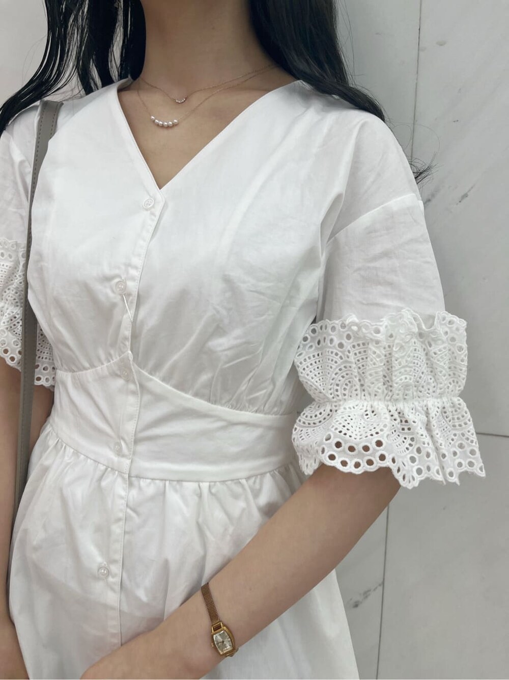 ホワイト系のワンピース、ホワイト系のパンプス、グレー系のハンドバッグを着用したレディースの春コーディネートの7枚目の写真