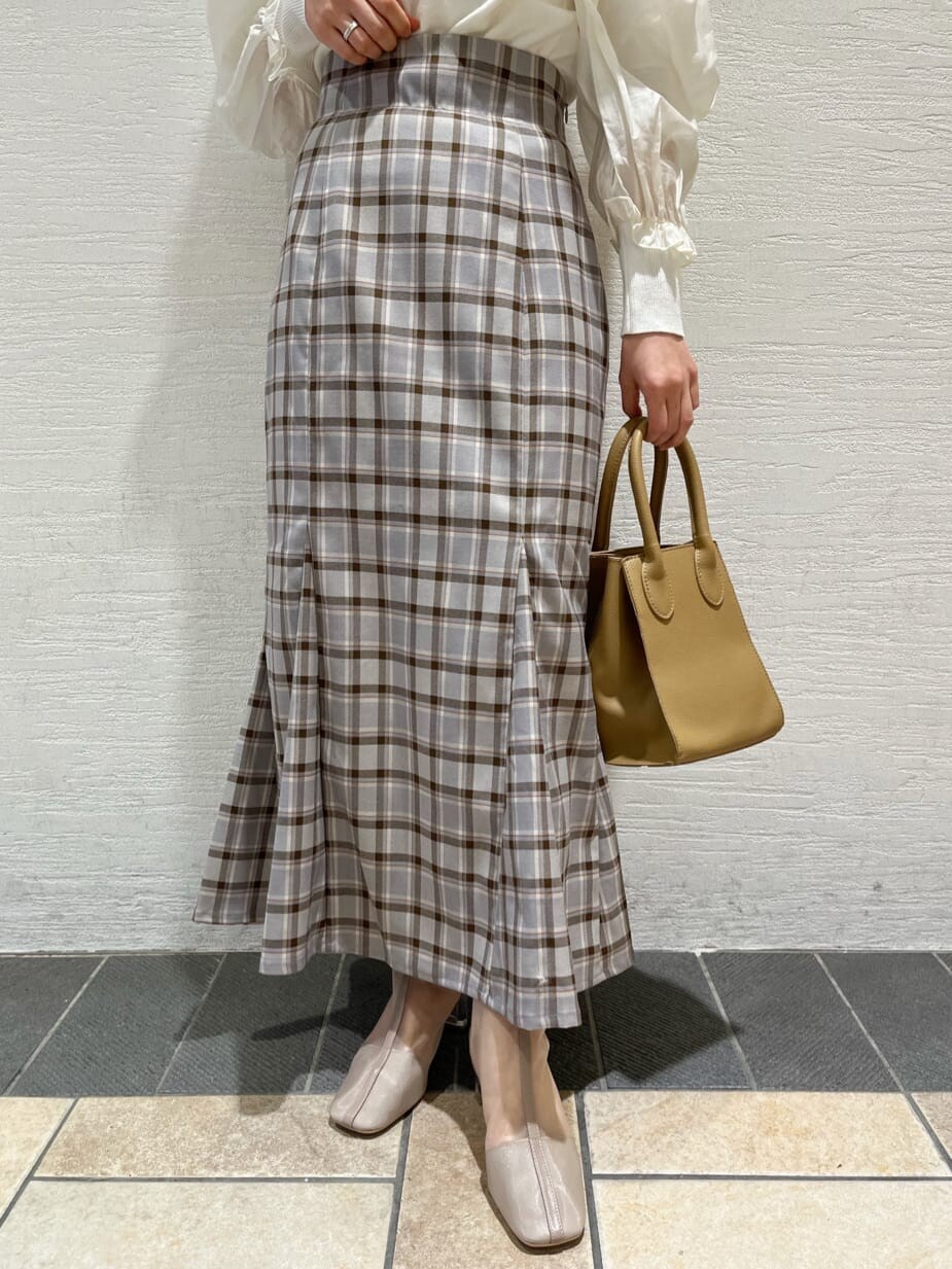 ベージュ系のブーツ、グレー系のスカート、ホワイト系のニット/セーターを着用したレディースの冬コーディネートの7枚目の写真