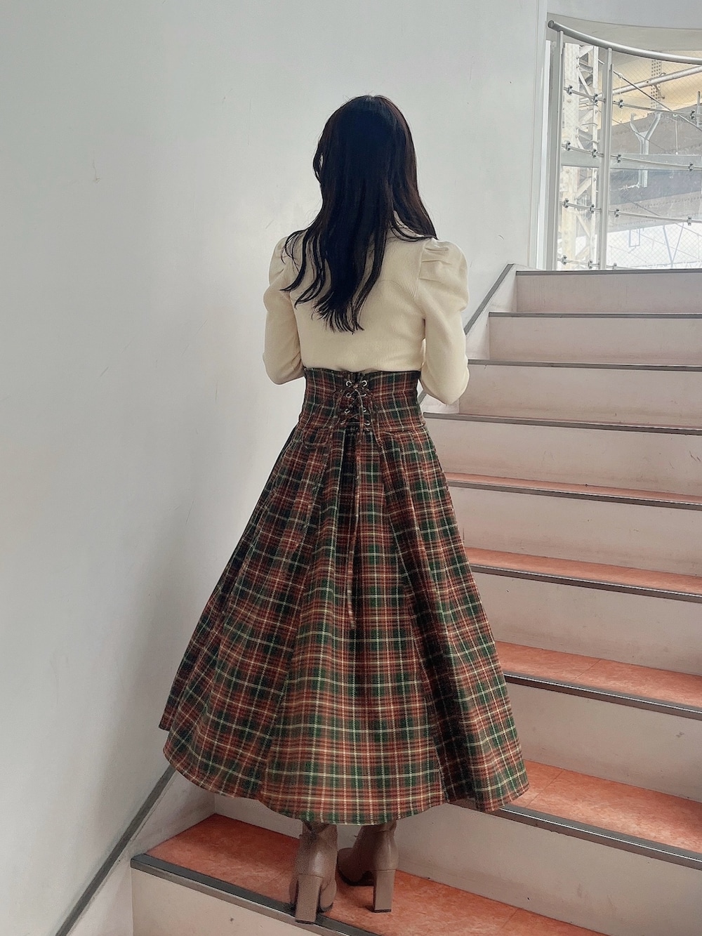 ホワイト系のニット/セーター、グリーン系のスカート、ベージュ系のブーツを着用したレディースの秋コーディネートの4枚目の写真