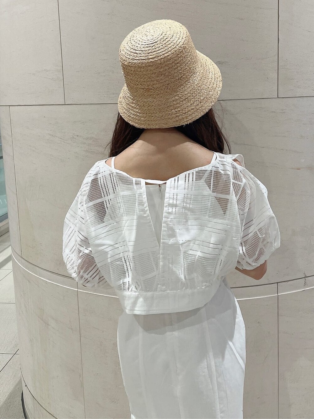 ホワイト系のワンピース、ホワイト系のサンダル、ベージュ系のハットを着用したレディースの夏コーディネートの6枚目の写真