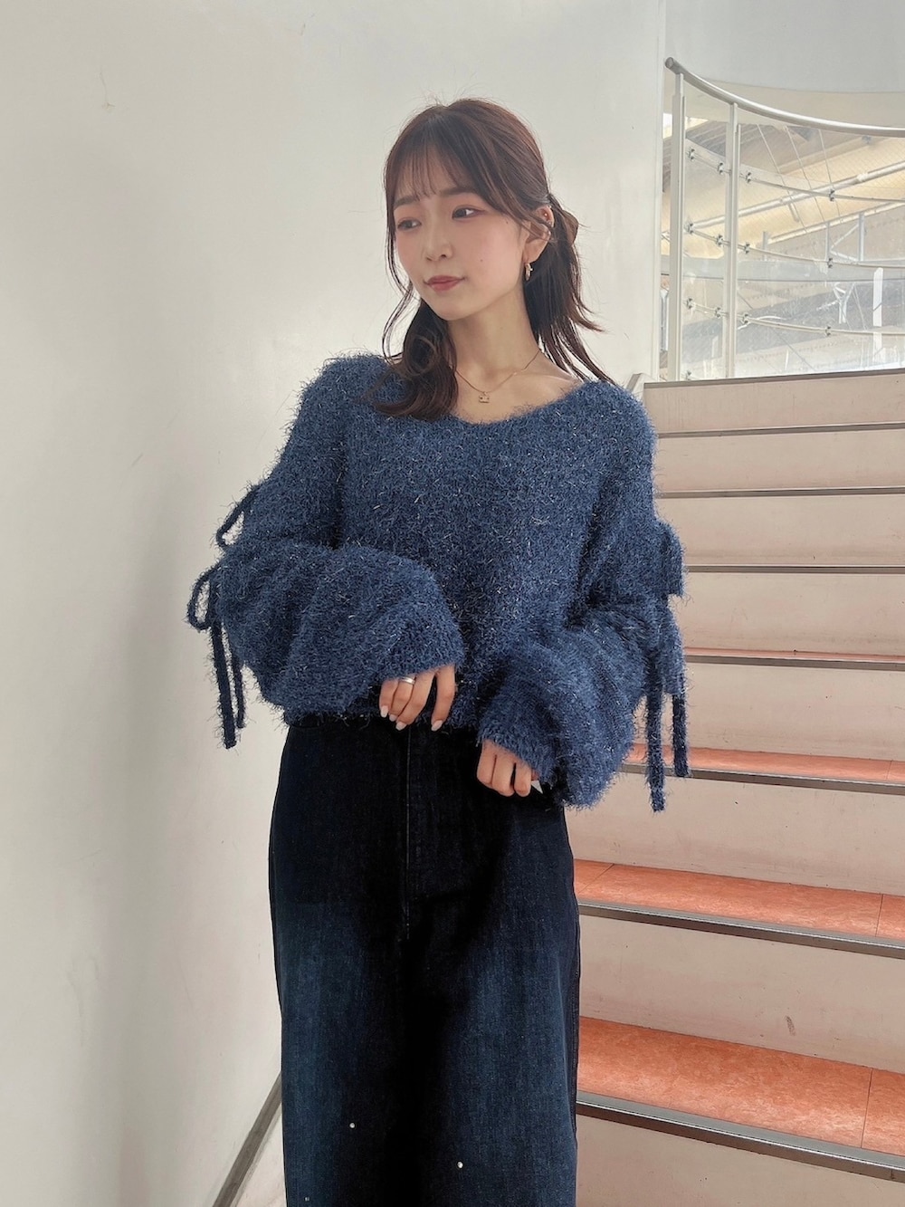 ブルー系のニット/セーター、ブルー系のデニムパンツ、ホワイト系のサンダルを着用したレディースの夏コーディネートの9枚目の写真