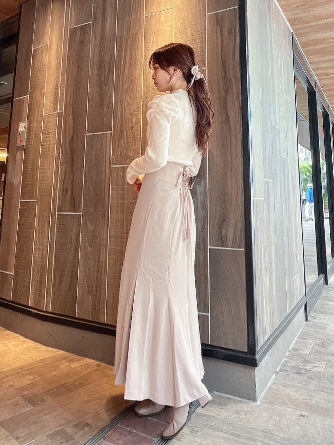 ベージュ系のブーツ、ベージュ系のスカート、ホワイト系のニット/セーターを着用したレディースの秋コーディネートの3枚目の写真