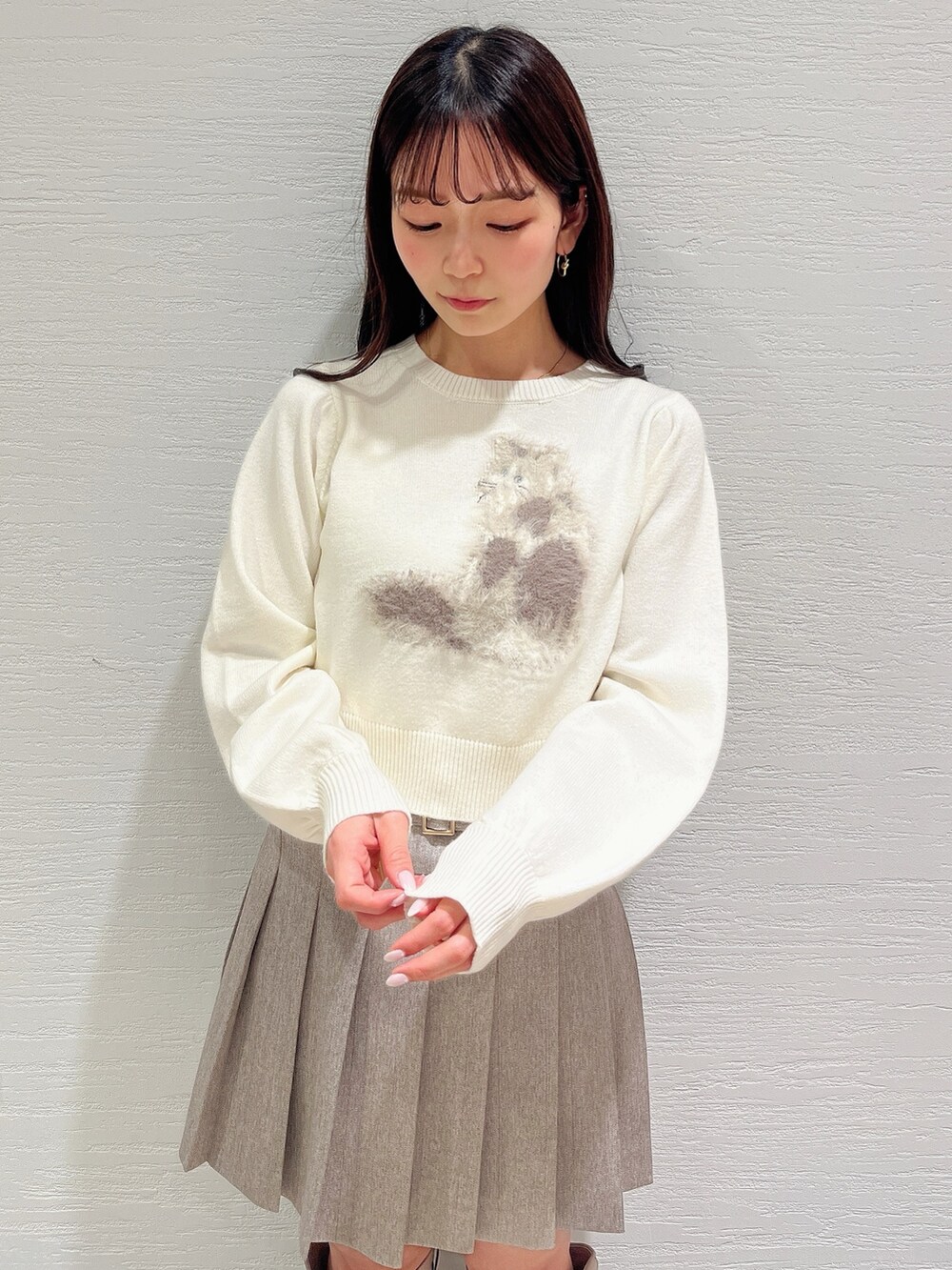 ホワイト系のニット/セーター、ベージュ系のスカート、ベージュ系のブーツを着用したレディースの冬コーディネートの8枚目の写真