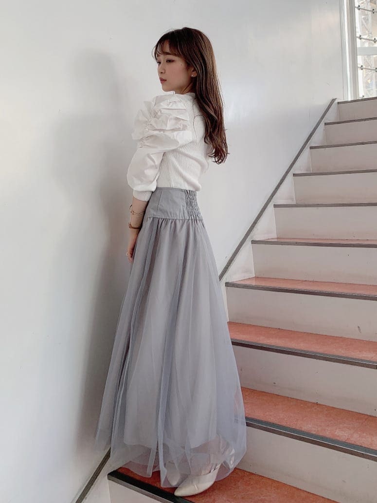 グレー系のスカート、ホワイト系のパンプス、ホワイト系のニット/セーターを着用したレディースの秋コーディネートの2枚目の写真