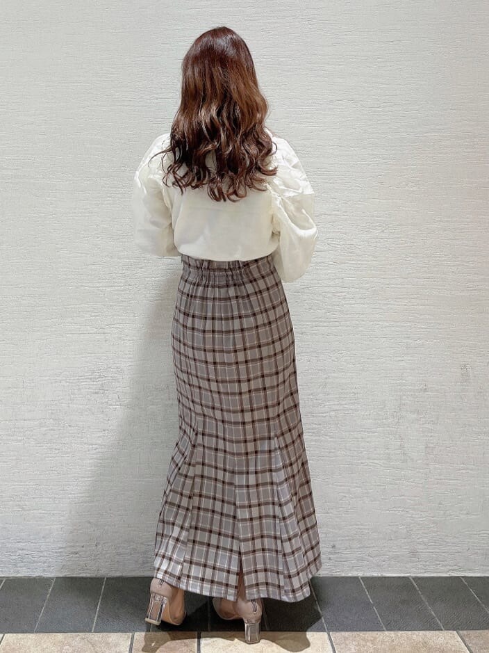 ベージュ系のブーツ、グレー系のスカート、ホワイト系のニット/セーターを着用したレディースの冬コーディネートの3枚目の写真