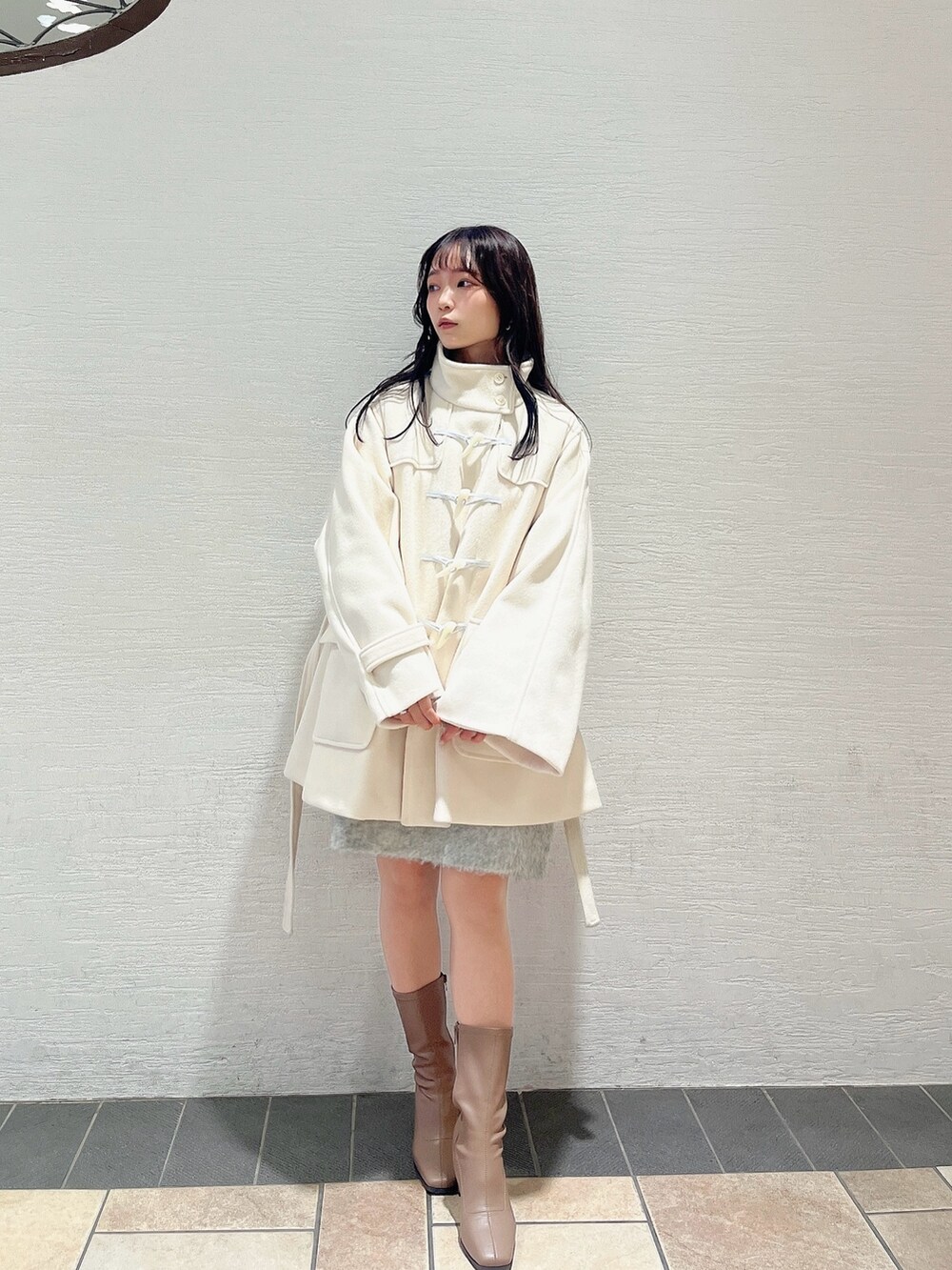 ベージュ系のブーツ、ホワイト系のダッフルコート、ピンク系のニット/セーターを着用したレディースの秋コーディネートの5枚目の写真