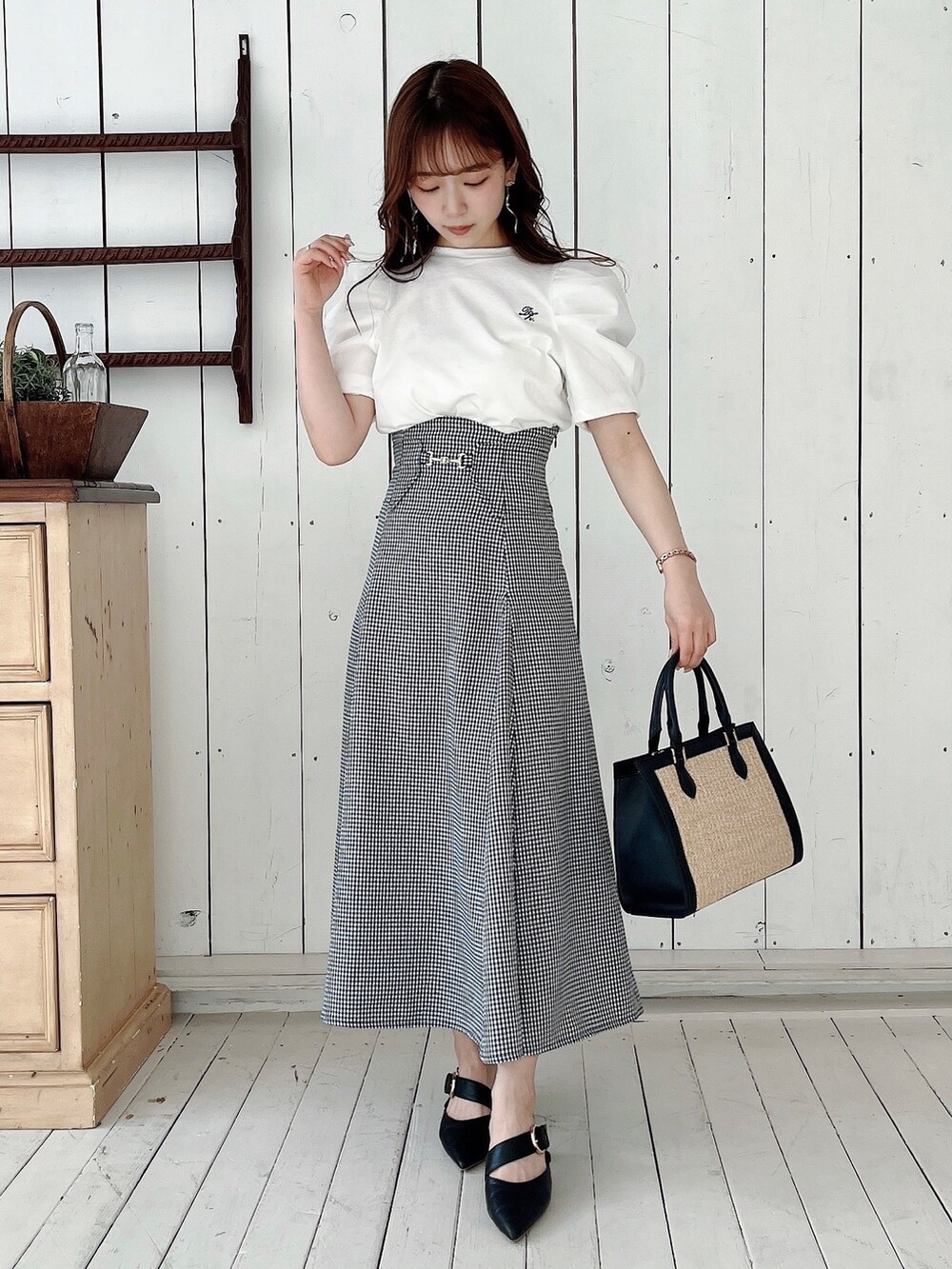 ホワイト系のTシャツ/カットソー、ブラック系のスカート、ブラック系のパンプスを着用したレディースの春コーディネートの9枚目の写真