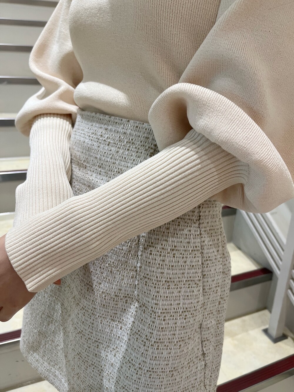 ホワイト系のニット/セーター、ホワイト系のスカート、ベージュ系のブーツを着用したレディースの冬コーディネートの8枚目の写真