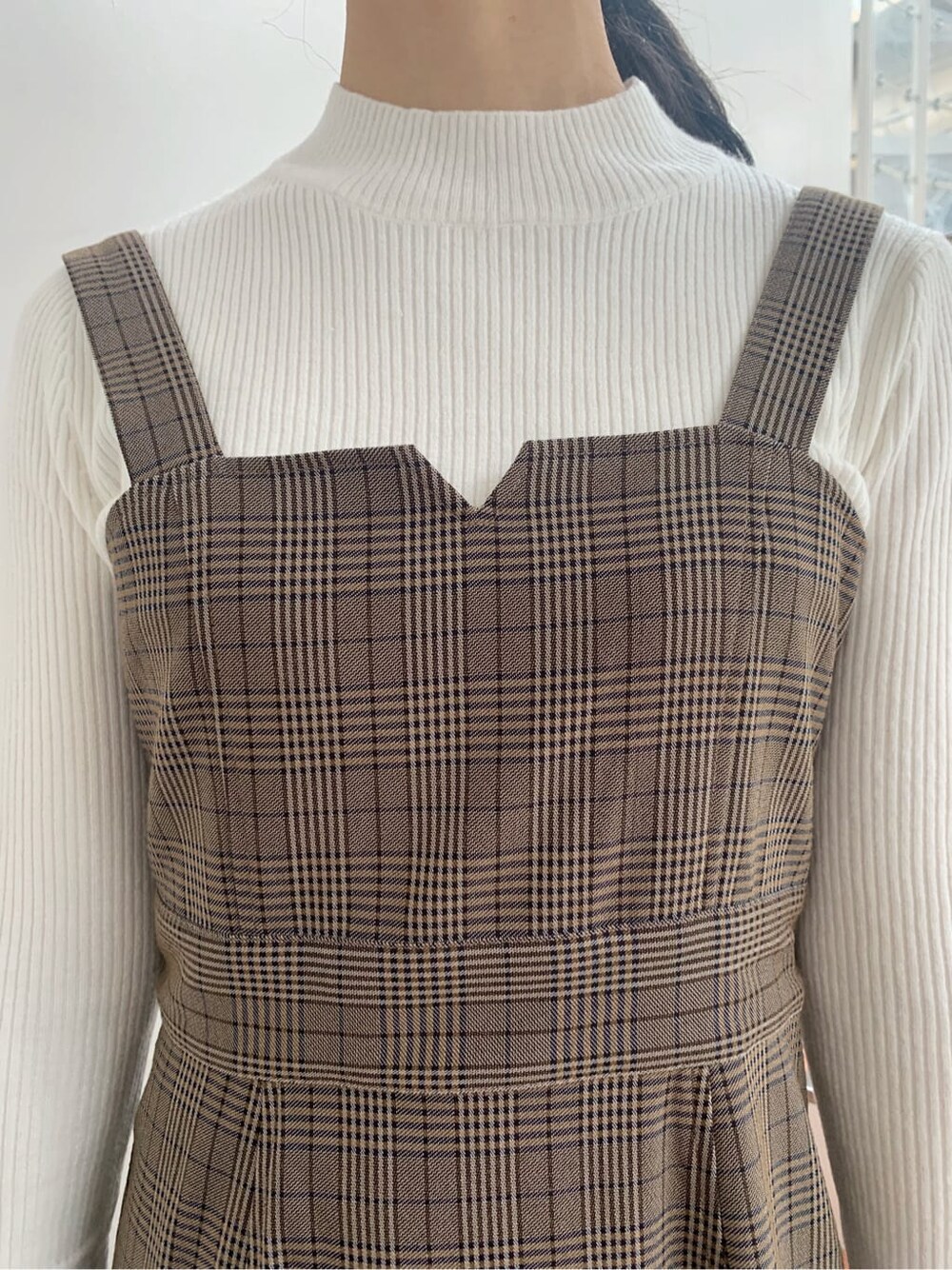 ベージュ系のトレンチコート、ベージュ系のブーツ、その他のジャンパースカートを着用したレディースの秋コーディネートの9枚目の写真