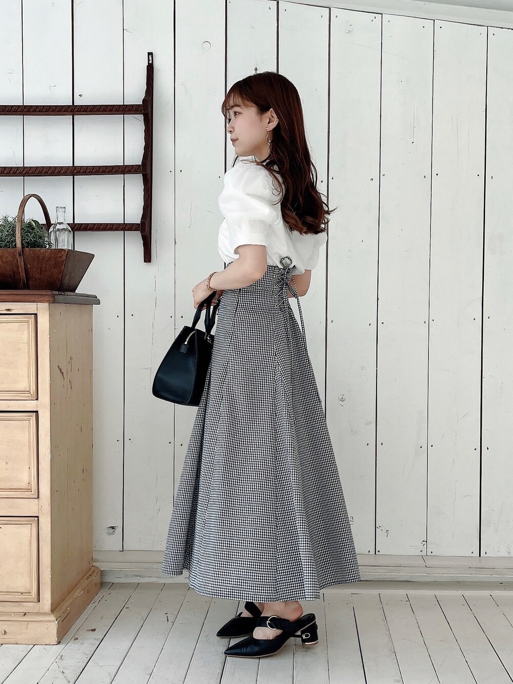 ホワイト系のTシャツ/カットソー、ブラック系のスカート、ブラック系のパンプスを着用したレディースの春コーディネートの7枚目の写真