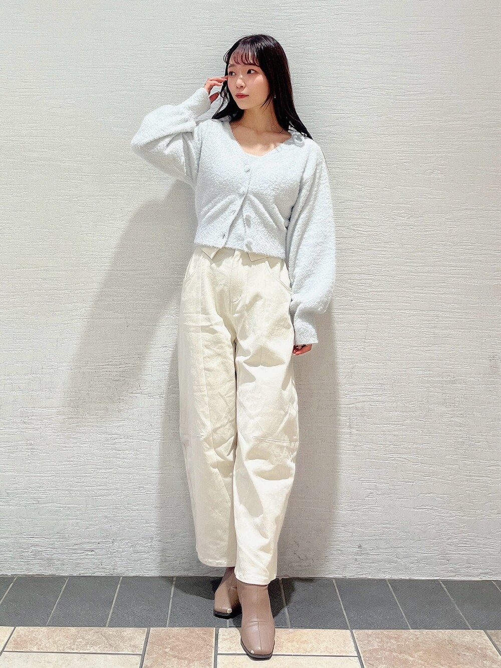 グレー系のキャミソール、グレー系のカーディガン/ボレロ、ホワイト系のデニムパンツを着用したレディースの冬コーディネートの6枚目の写真