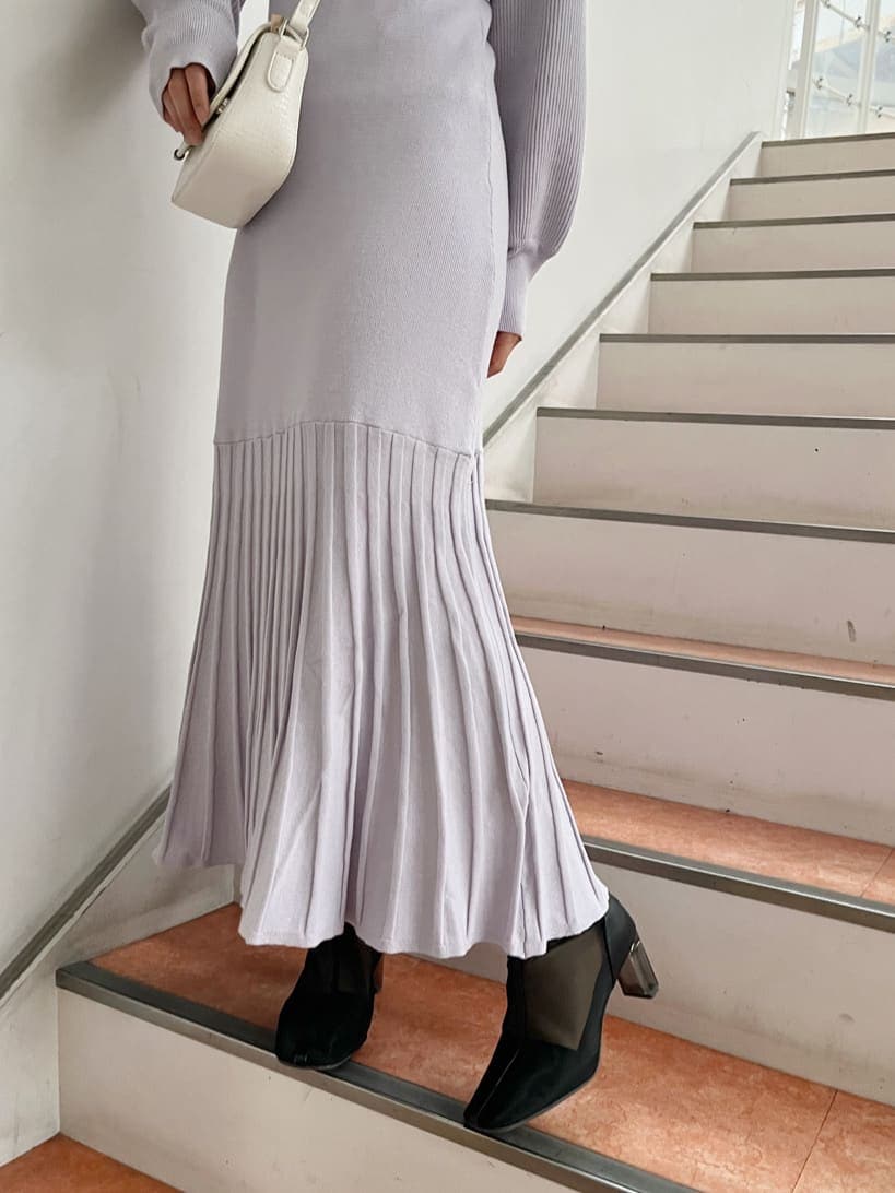 パープル系のワンピース、ブラック系のブーツ、ホワイト系のショルダーバッグを着用したレディースの冬コーディネートの8枚目の写真