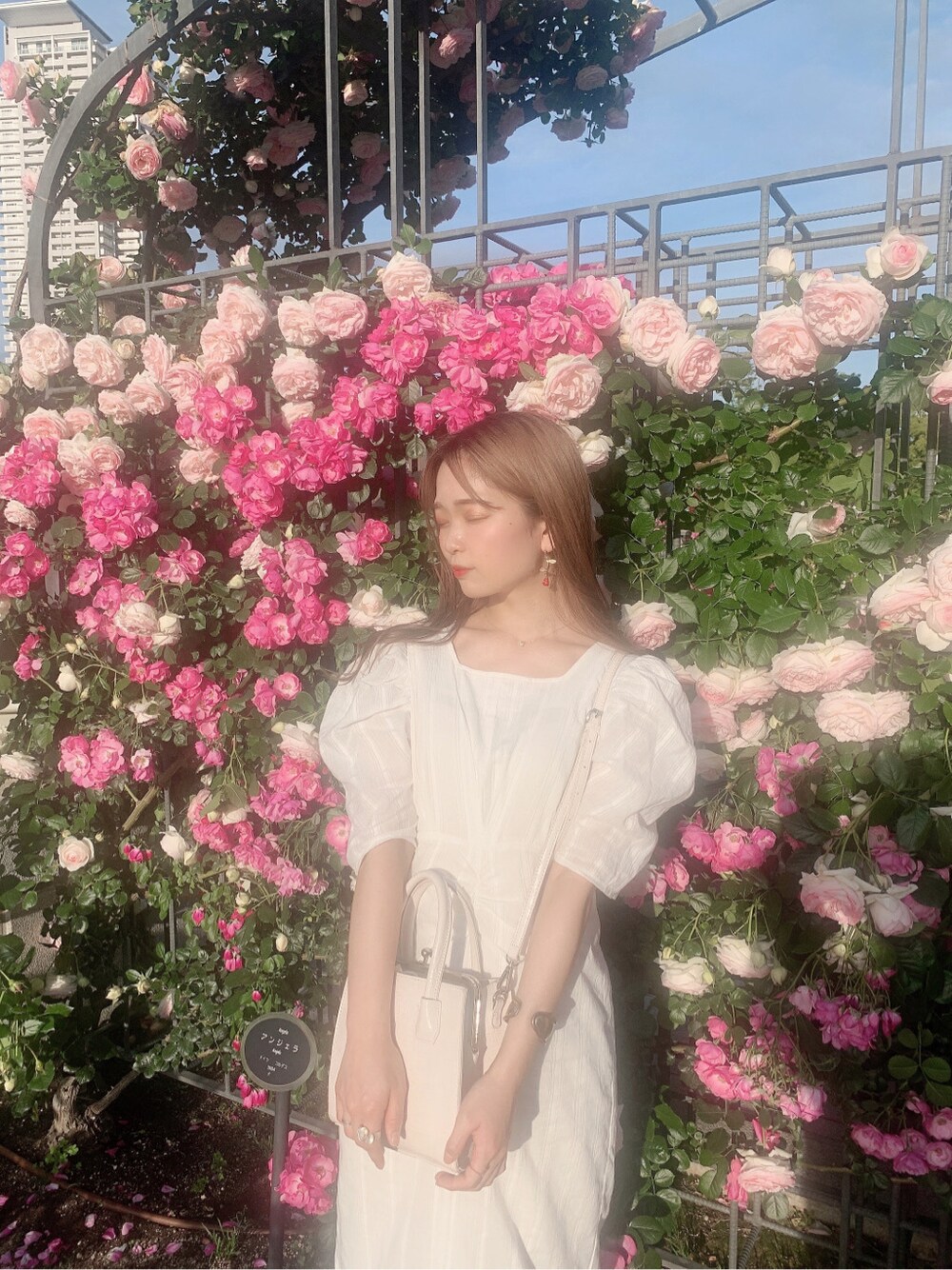 ホワイト系のパンプス、ホワイト系のワンピースを着用したレディースの春コーディネートの2枚目の写真