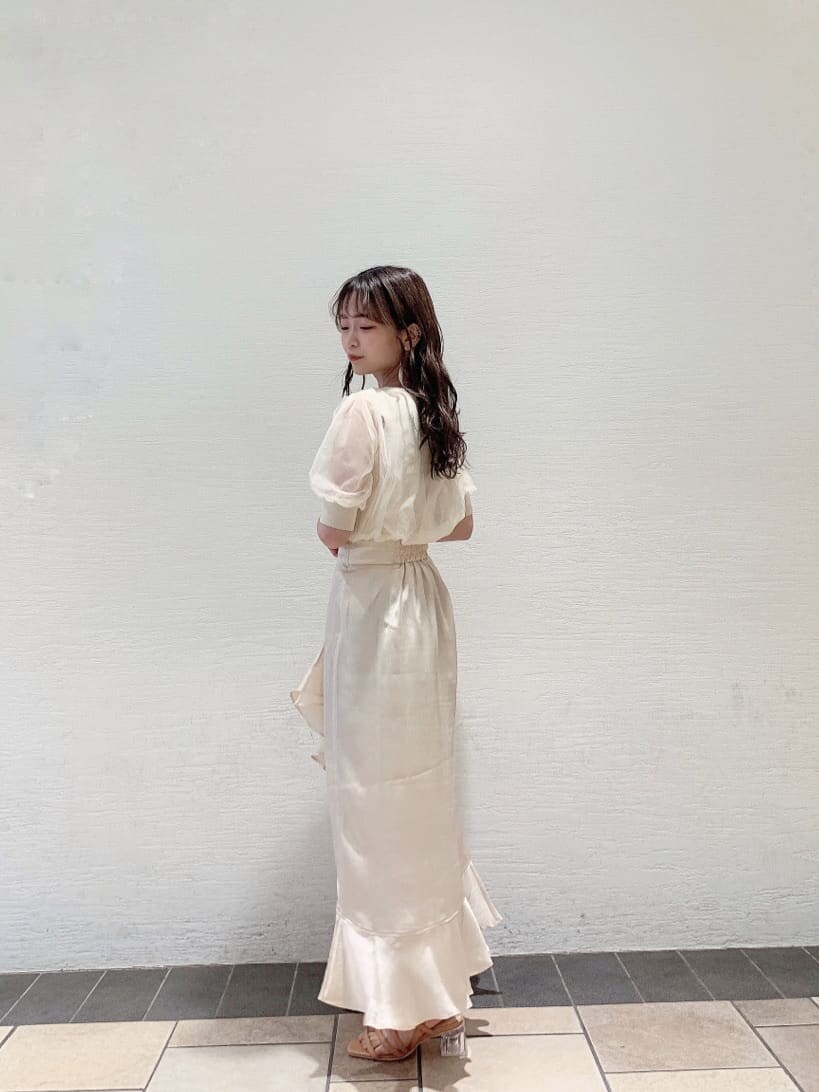 ホワイト系のスカート、ホワイト系のニット/セーター、オレンジ系のサンダルを着用したレディースの夏コーディネートの4枚目の写真