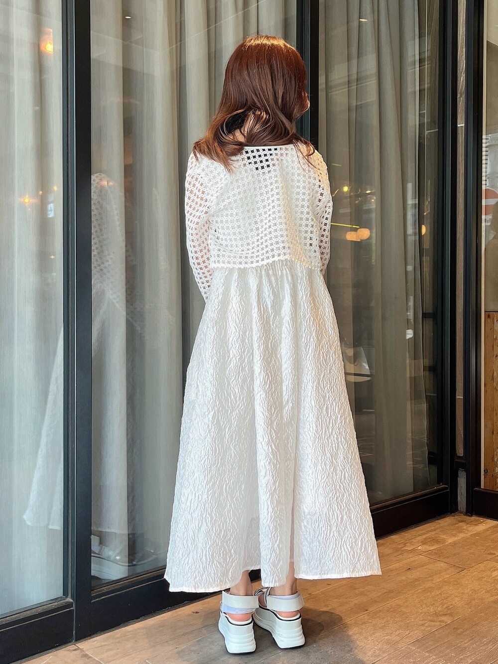 ホワイト系のドレス、ホワイト系のカーディガン/ボレロ、ホワイト系のサンダルを着用したレディースの夏コーディネートの3枚目の写真
