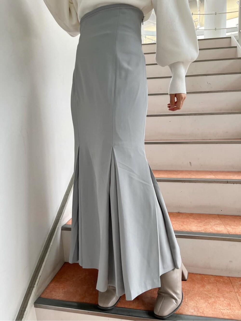 ベージュ系のブーツ、グレー系のスカート、ホワイト系のニット/セーターを着用したレディースの秋コーディネートの9枚目の写真