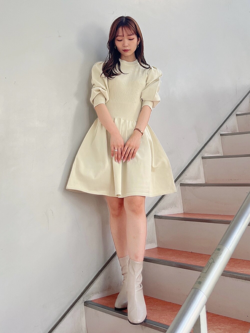 ベージュ系のブーツ、ホワイト系のワンピースを着用したレディースの秋コーディネートの2枚目の写真