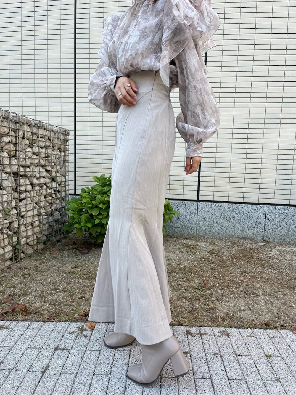 ベージュ系のスカート、ベージュ系のブーツ、ベージュ系のシャツ/ブラウスを着用したレディースの秋コーディネートの9枚目の写真